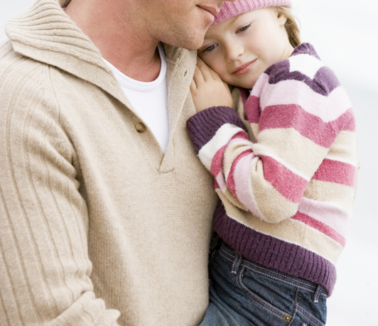 Father holding daughter at beach