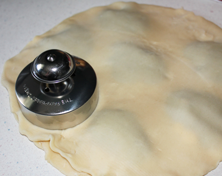 Cover with the top crust and using the mounds below, cut using the cutter. If you don't have one of these handy little cutters that seal the edges, just use a drinking glass to cut out and then crimp the edges with a fork or your fingers.